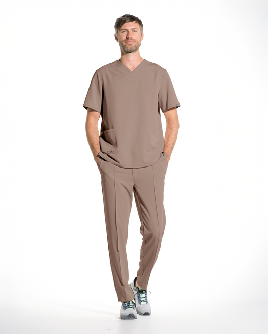 Bluza medicala barbateasca cappuccino purtata din fata, cu mainile in buzunare